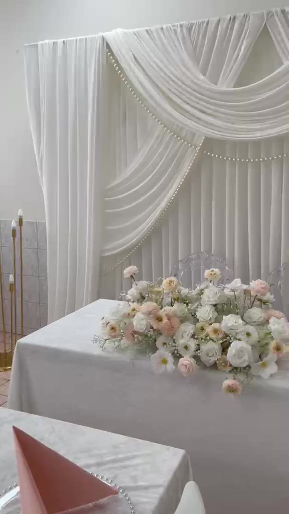 Brautpaartisch mit weisser Rückwand, Perlenbögen und Blumengesteck
